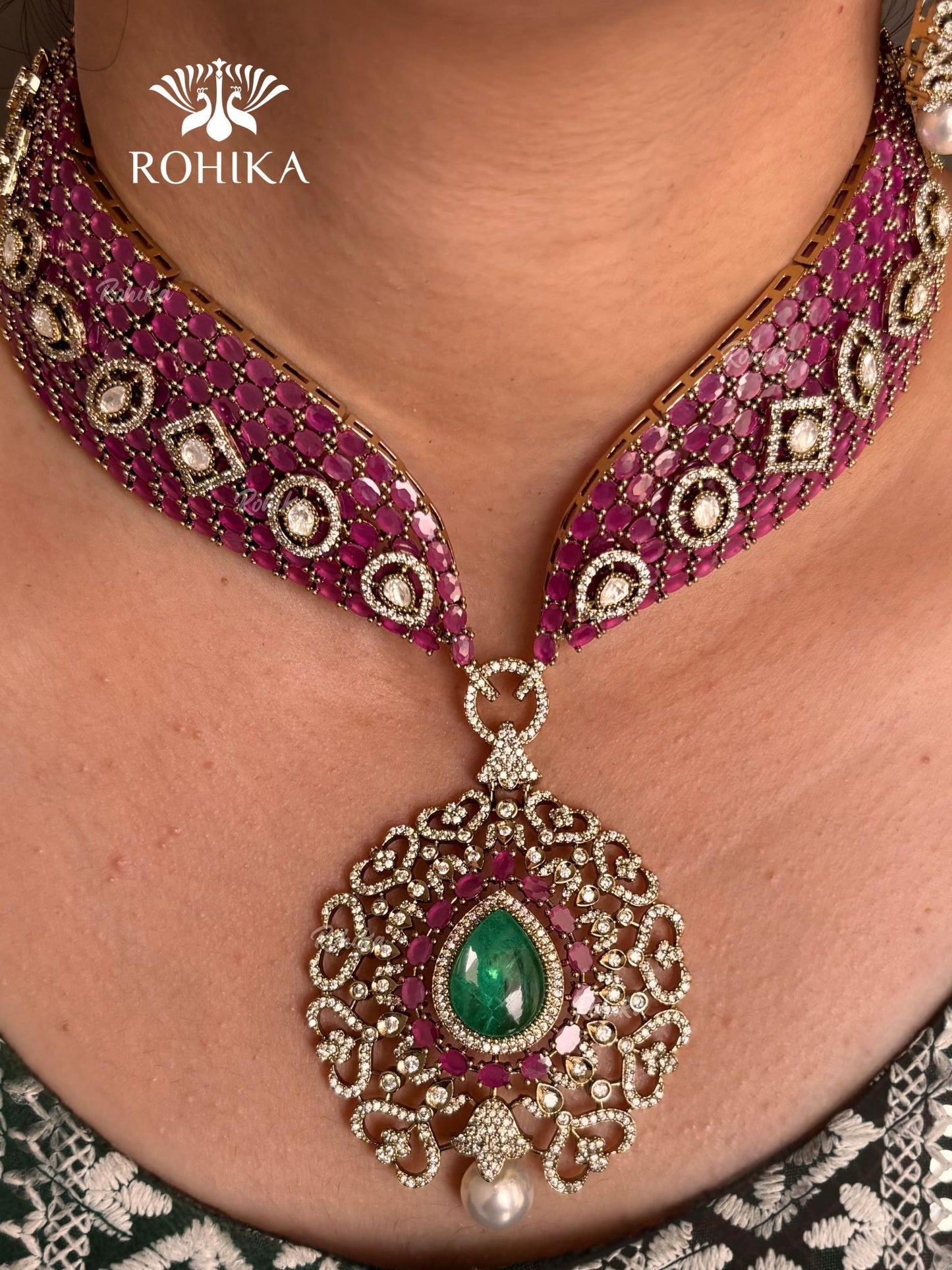 Pink and green color kundan necklace set on a grey dummy