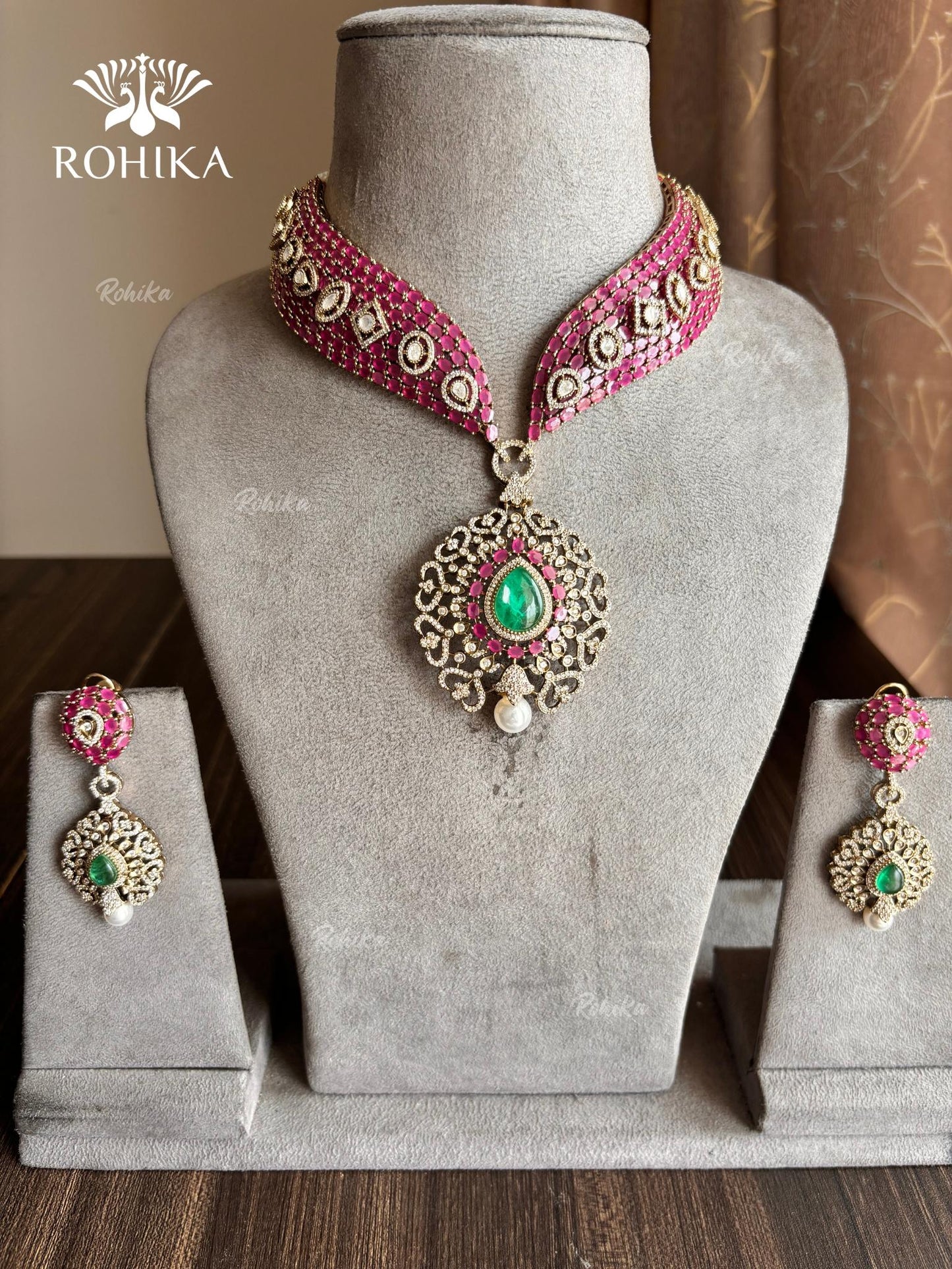 Pink and green color kundan necklace set on a grey dummy