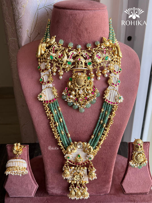 Gold and green jewelry set on a pink mannequin with 'Rohika' branding.