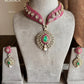 Pink and green color kundan necklace set on a grey dummy